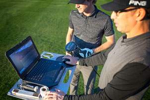 Fitter and golfer looking at laptop computer