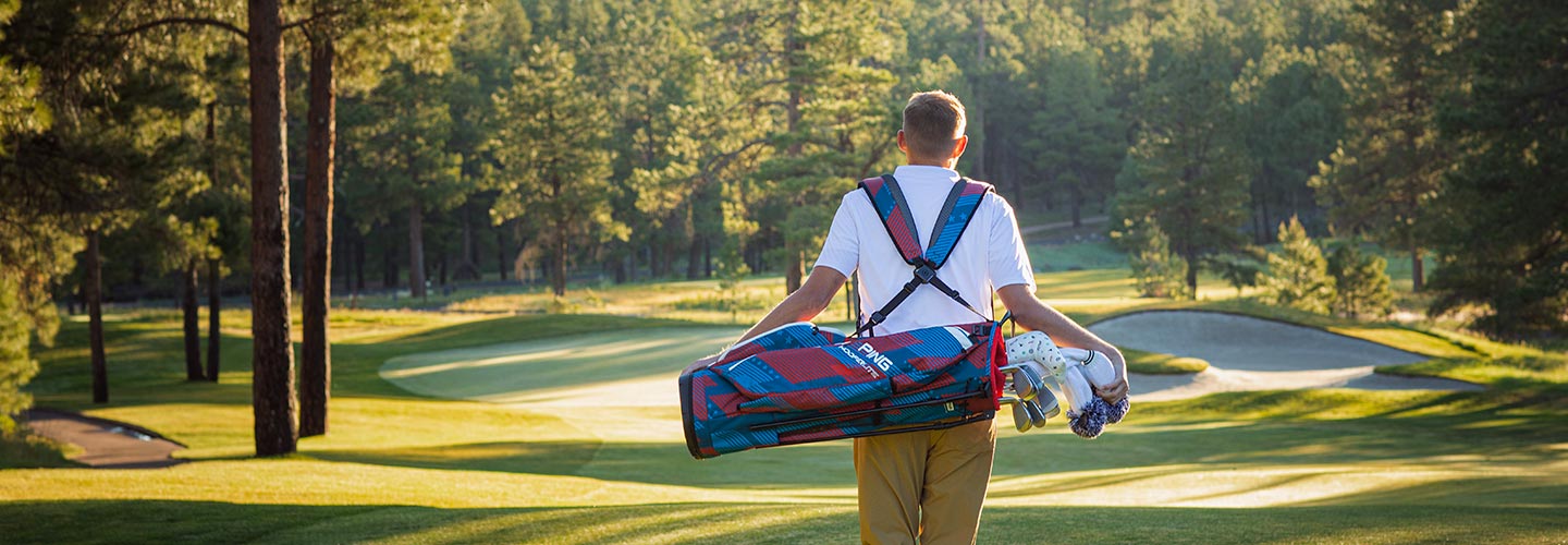 Image of golfer carrying the 2023 Hoofer Lite Golf Bag in Stars and Stripes pattern