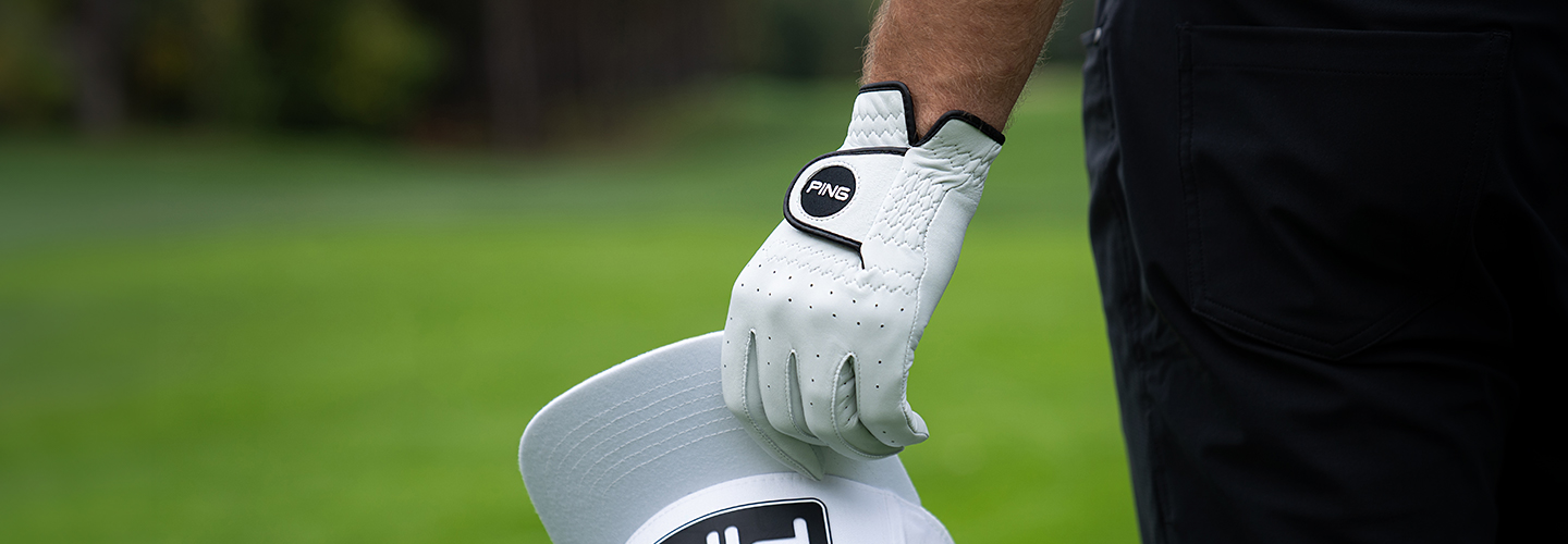 Image of golfer wearing the PING Tour Glove and holding the PING Tour Snpaback