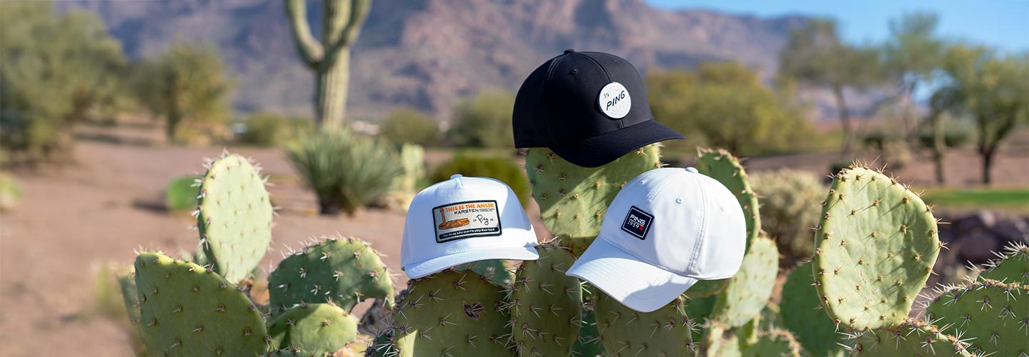 Lifestyle image of caps laying on cacti on a golf course